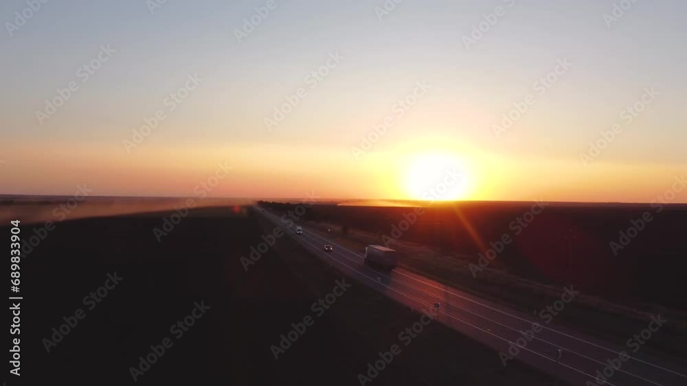 the track at sunset and the cars driving along it the track at sunset and the cars driving along it