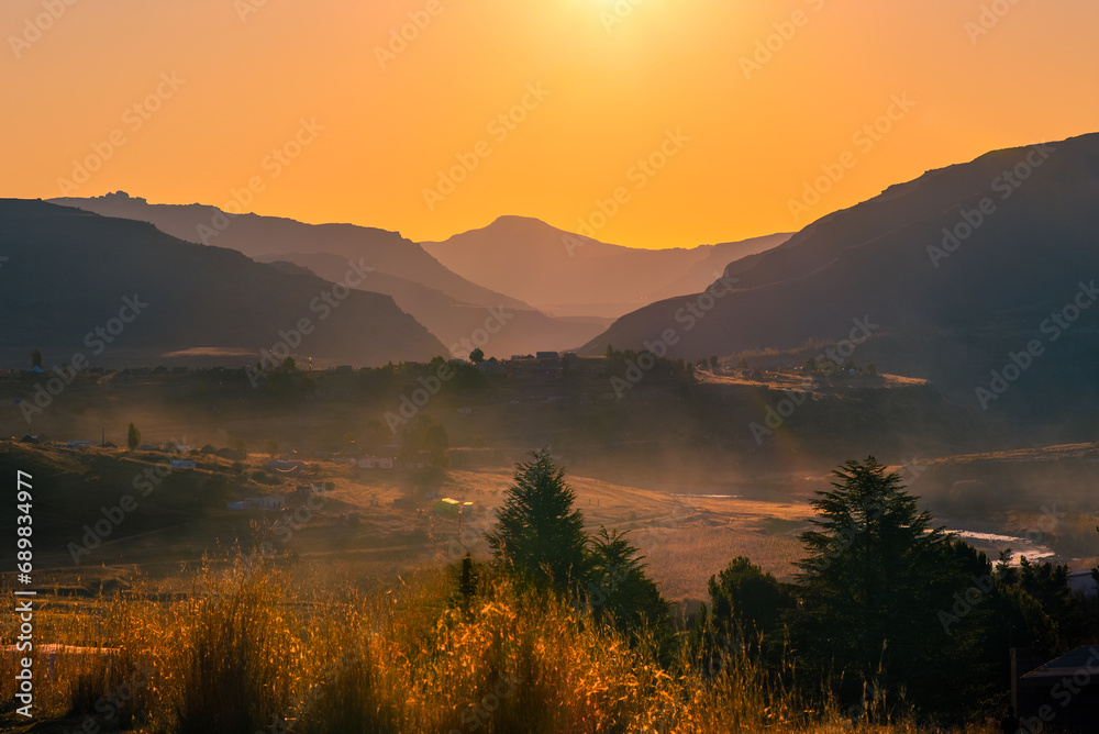 Fototapeta premium Golden light at sunset over the mountains in rural Lesotho