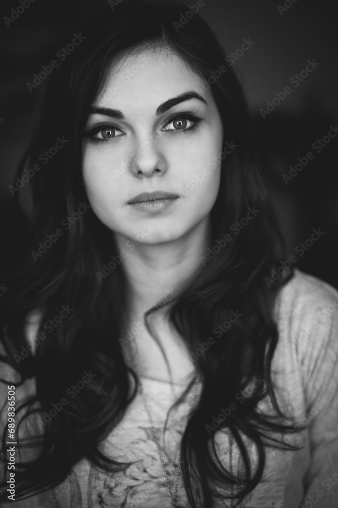 Close up portrait of a beautiful young brunette woman with long hair. Black and white photo
