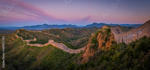 Panoramic view of the Great Wall of China at sunset across the mountain in China. photo