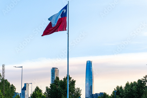 La bandera de Chile flameando con la ciudad De Santiago de fondo en el atardecer. Tomada en la comuna de Vitacura.  photo