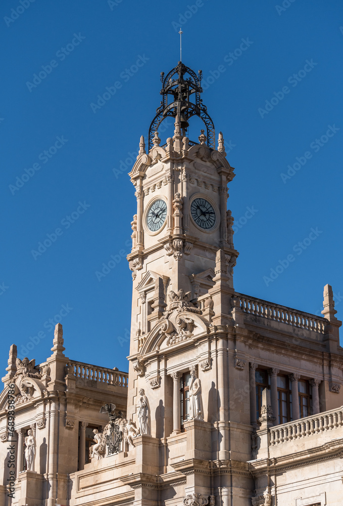 Valencia, Spain -September 23th, 2023: Clock tower in the Spanish city of Valencia, Mediterranean architecture. The Town Hall, Placa de l'Ajuntament (Plaza del Ayuntamiento).