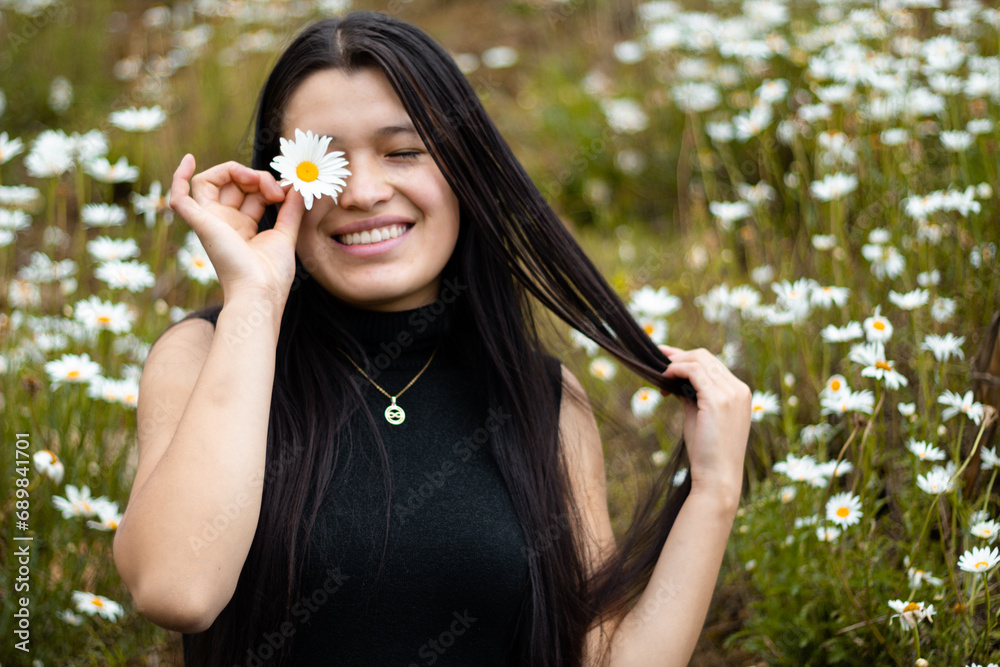 Mujer atractiva cubriendo los ojos con ramas de flores durante la primavera Mujer atractiva cubriendo los ojos con ramas de flores durante la primavera