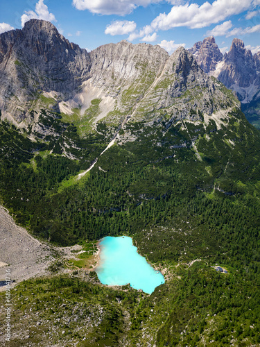 Aerial view of the blue turquoise Lake Sorapis, Lago di Sorapiss, with mountains with the background in Dolomites. One of the most beautiful lakes in Italy. Famous destination. photo