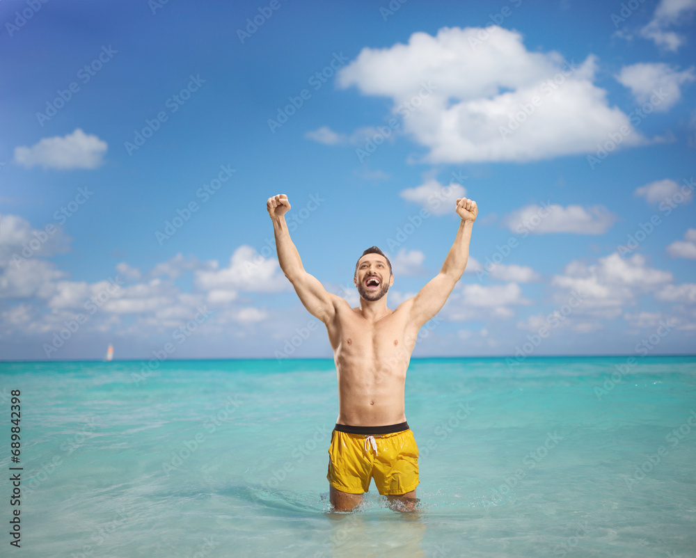 Excited man in a swimming suit standing in the sea Excited man in a swimming suit standing in the sea