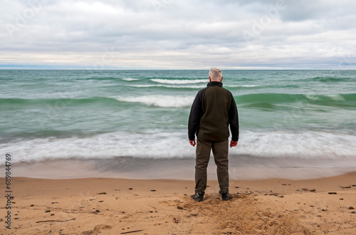 Senior citizen hiker on shore of Lake Michigan of the Great Lakes 