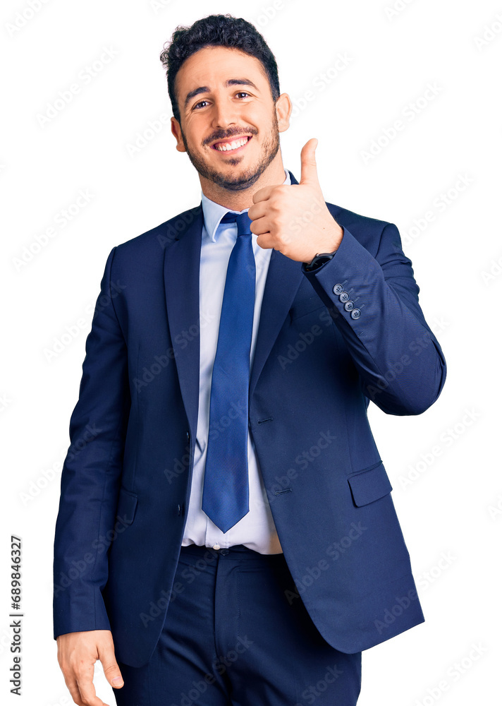 Young hispanic man wearing business clothes smiling happy and positive, thumb up doing excellent and approval sign Young hispanic man wearing business clothes smiling happy and positive, thumb up doing excellent and approval sign
