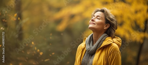 Autumn forest, middle-aged woman stretching and breathing fresh air. photo
