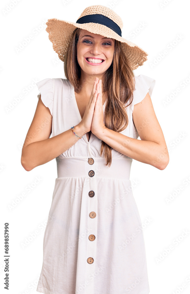 Young beautiful blonde woman wearing summer dress and hat praying with hands together asking for forgiveness smiling confident. Young beautiful blonde woman wearing summer dress and hat praying with hands together asking for forgiveness smiling confident.