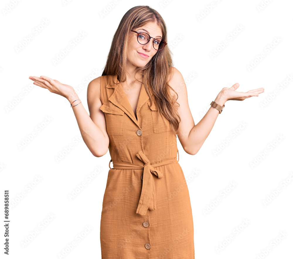 Φωτογραφία Young beautiful blonde woman wearing casual clothes and glasses clueless and confused expression with arms and hands raised