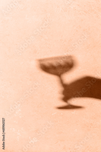 Glass shadow on peach background. Shadow overlay effect, organic shadows, texture reflection. Non-alcoholic, zero-proof drinks, sober concept. Peach fuzz pantone color of year 2024 stylish flat lay.