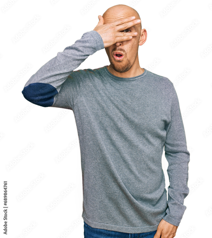 Bald man with beard wearing casual clothes peeking in shock covering face and eyes with hand, looking through fingers with embarrassed expression. Bald man with beard wearing casual clothes peeking in shock covering face and eyes with hand, looking through fingers with embarrassed expression.