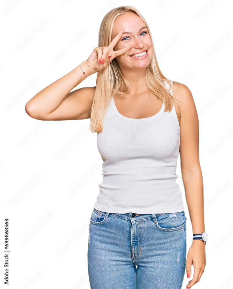 Young blonde girl wearing casual style with sleeveless shirt doing peace symbol with fingers over face, smiling cheerful showing victory Young blonde girl wearing casual style with sleeveless shirt doing peace symbol with fingers over face, smiling cheerful showing victory