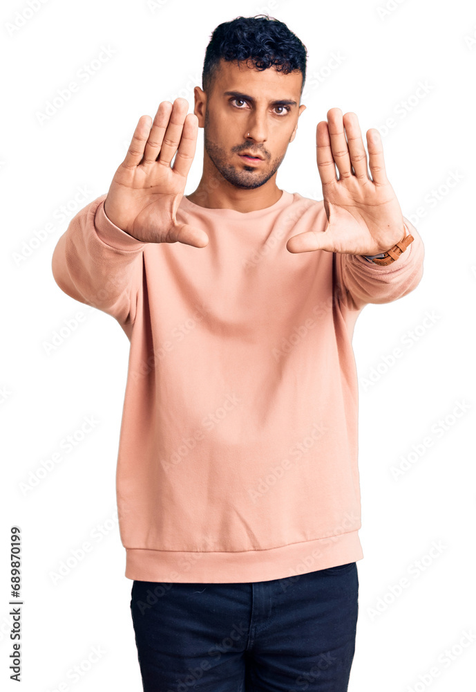 Young hispanic man wearing casual clothes doing frame using hands palms and fingers, camera perspective