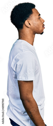 Young african american man wearing casual white t shirt looking to side, relax profile pose with natural face and confident smile.