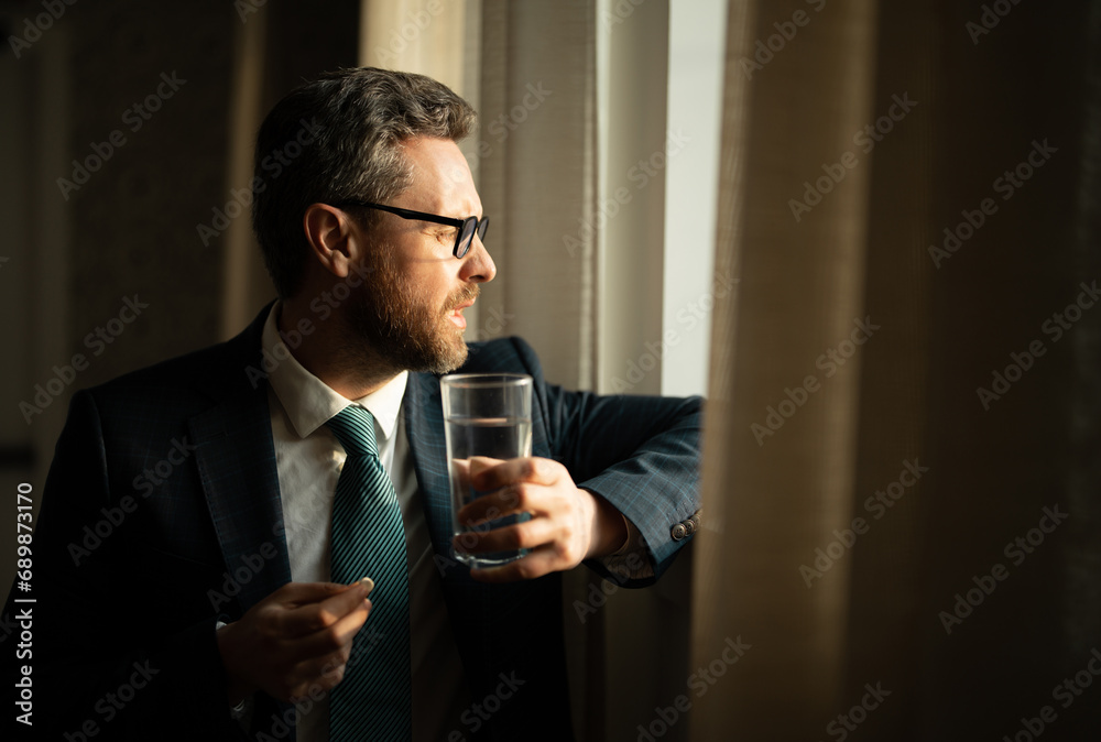 Tired man feel pain holding glasses rubbing dry irritated eyes fatigued from computer work. Man taking a Medicine pill from headache migraine. Tired man feel pain holding glasses rubbing dry irritated eyes fatigued from computer work. Man taking a Medicine pill from headache migraine.