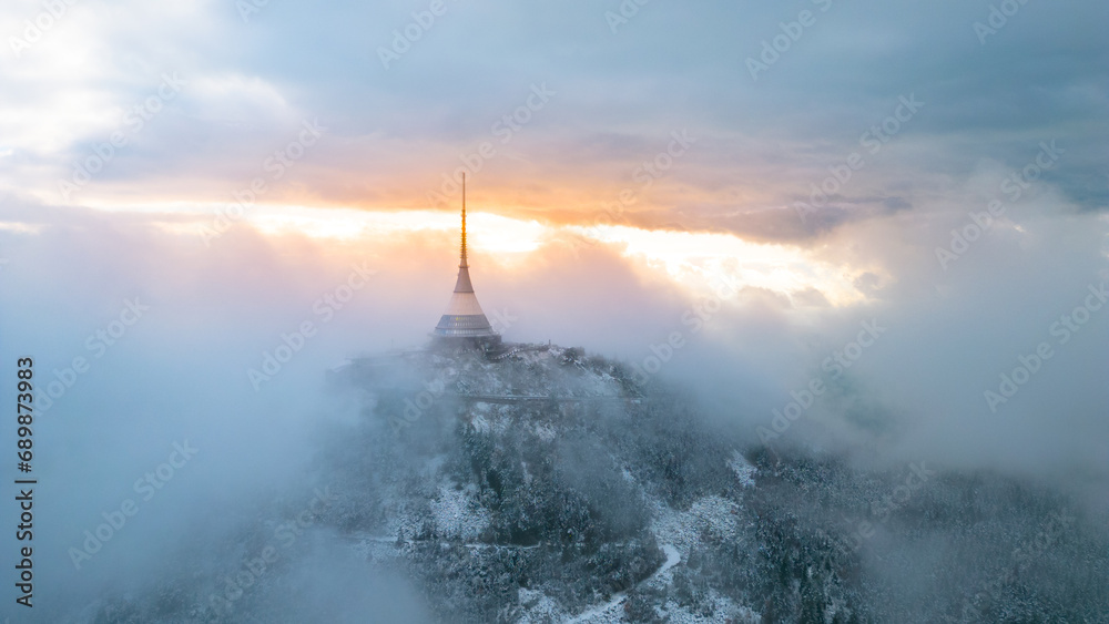 Fototapeta premium Jested mountain with modern hotel and TV transmitter on the top, Liberec, Czech Republic. Building in clouds. Aerial view from drone.