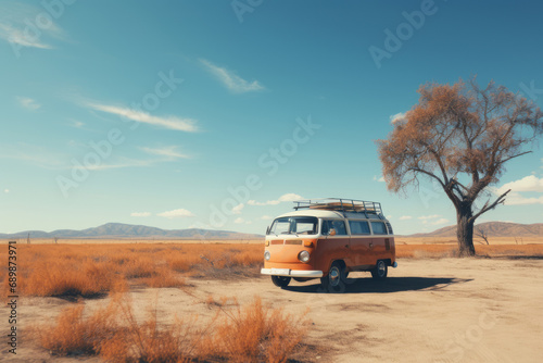 A colorful retro van drives off along a deserted dirt road towards the distant mountains on the horizon. The concept of romantic travel, summer vacations, family vacations, car tourism