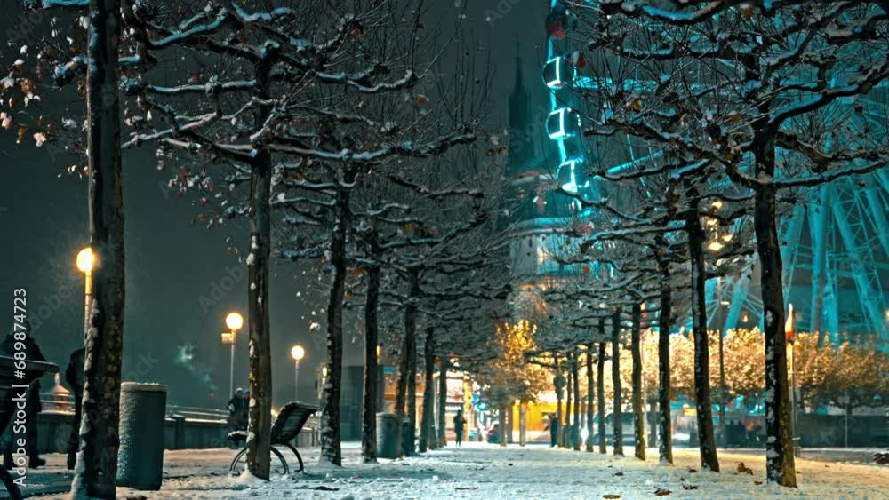 Ferris wheel on Rhine in Dusseldorf during snowfall in evening. Close-up