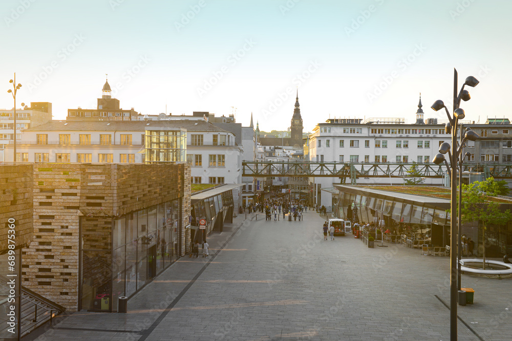 Fototapeta premium View of city street with buildings and walking people