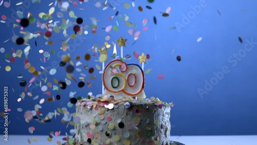 Celebrating 60 year old age symbolized in birthday cake with confetti falling in slow-motion with candle, anniversary milestone celebration photo