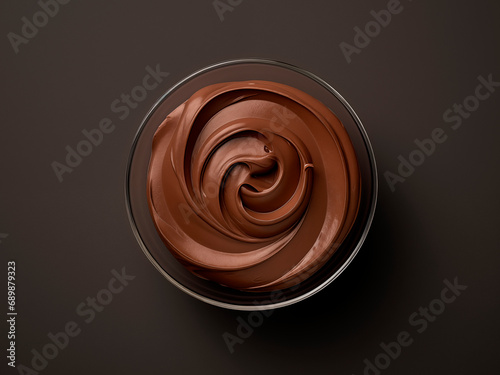 Bowl of hazelnut cream, chocolate paste swirl on black background photo