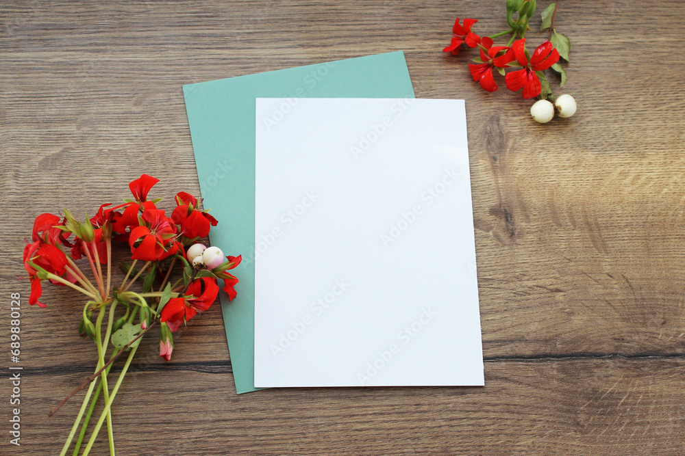 Greeting and wedding invitation card with copy space and envelope mock up, vertical flat composition with floral decoration and wooden background postcard template.