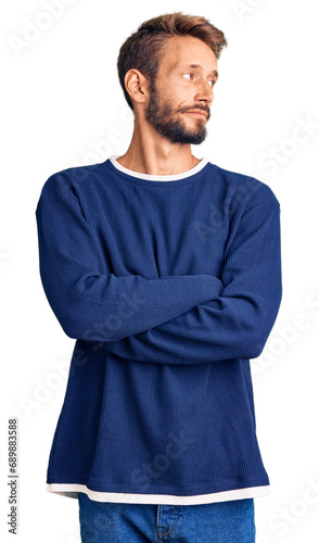 Handsome blond man with beard wearing casual sweater looking to the side with arms crossed convinced and confident