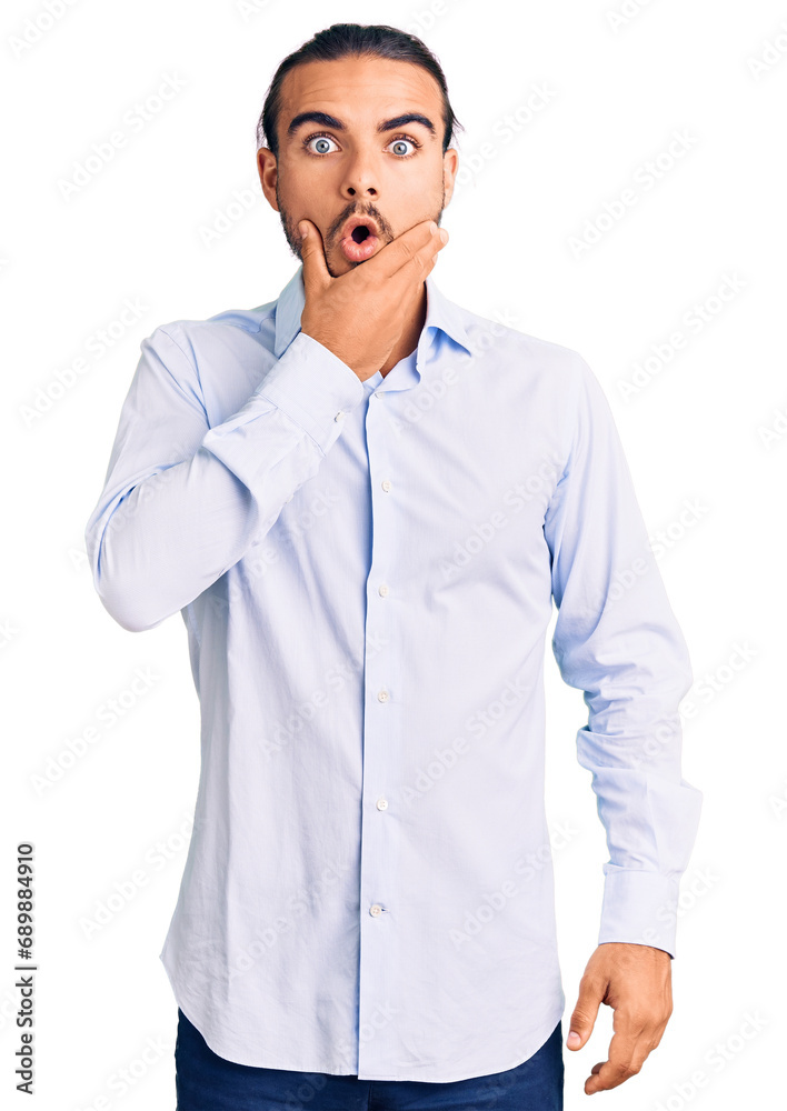 Young handsome man wearing business clothes looking fascinated with disbelief, surprise and amazed expression with hands on chin Young handsome man wearing business clothes looking fascinated with disbelief, surprise and amazed expression with hands on chin