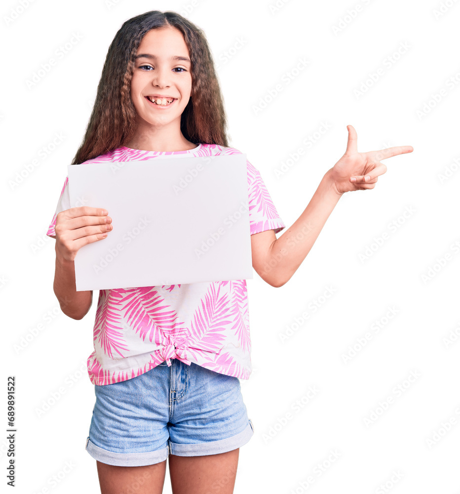 Cute hispanic child girl holding blank empty banner smiling happy pointing with hand and finger to the side Cute hispanic child girl holding blank empty banner smiling happy pointing with hand and finger to the side