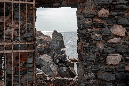 stone window or opening in a stone wall overlooking scenic landscape of ligurian sea and rocky cliffs in Portovenere, Italy. photo