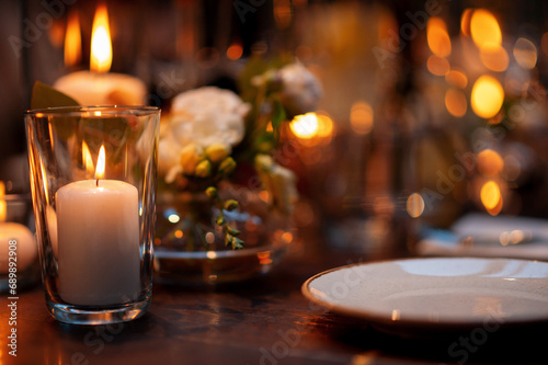 Close up of wedding table setting with candles and plates on the wooden table
