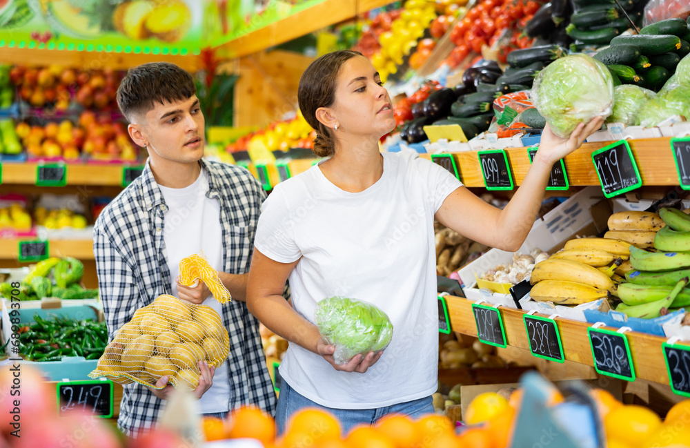 Φωτογραφία Happy young married couple who came to the store for shopping, chooses products