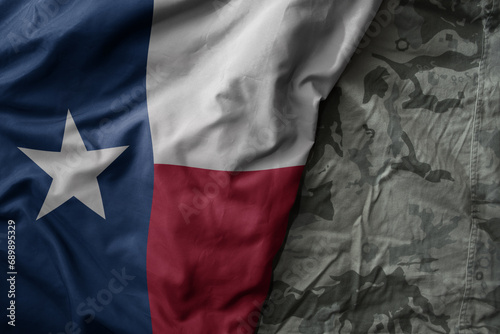waving flag of texas state on the old khaki texture background. military concept. photo