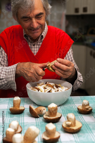 Senior Man Enjoy Cleaning Porcini Mushrooms at Home with Porcelain Kitchen Knife