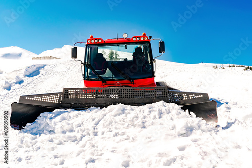 Foto Red modern snowcat ratrack with snowplow,snow grooming machine,remover truck preparing ski slope,piste,hill at alpine skiing winter resort