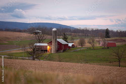 View of red barn and silo near crop field on Pennsylvania farm  photo