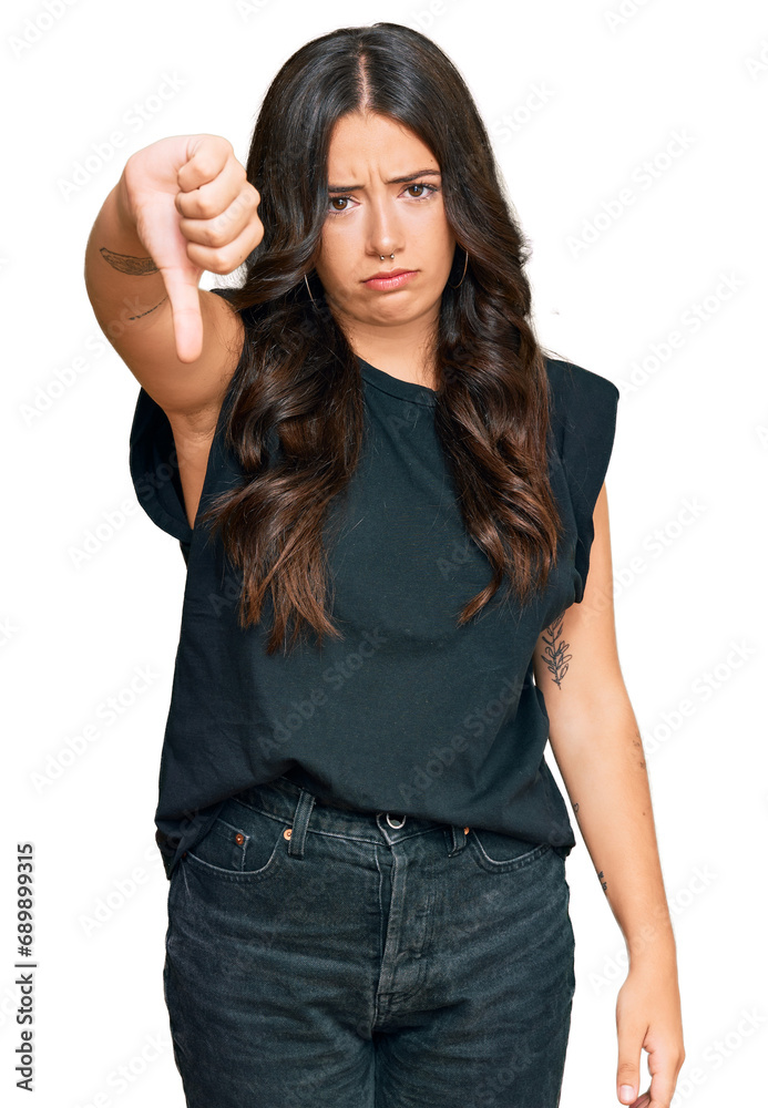 Obraz premium Beautiful brunette young woman wearing black shirt looking unhappy and angry showing rejection and negative with thumbs down gesture. bad expression.