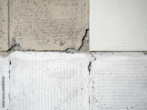 background of broken white tiles. The wall needs repairs. The concept of ruin and abandonment. Chipped tile