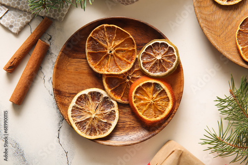 Wallpaper Mural Wooden plate with dried orange slices and cinnamon on white background Torontodigital.ca