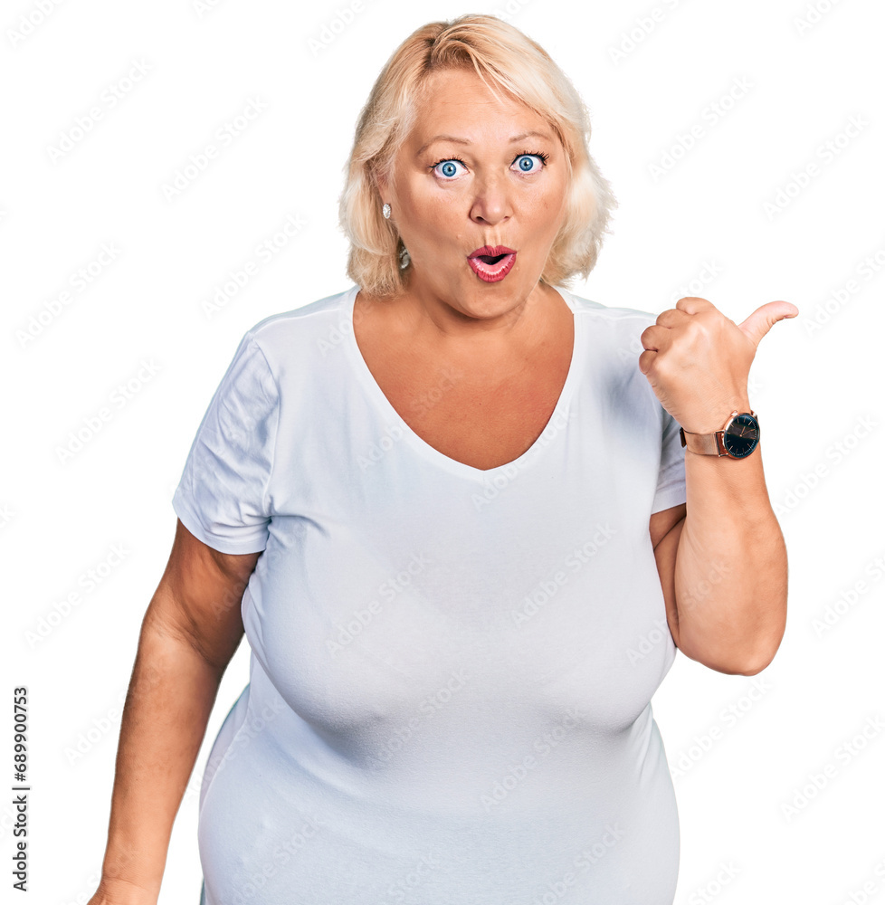 Middle age blonde woman wearing casual white t shirt surprised pointing with hand finger to the side, open mouth amazed expression. Middle age blonde woman wearing casual white t shirt surprised pointing with hand finger to the side, open mouth amazed expression.