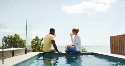 Cheers, drinks and happy couple at pool at ocean resort, hotel or holiday celebration of interracial marriage. Smile, toast and wine, man and woman on vacation with love, travel and beach terrace. photo