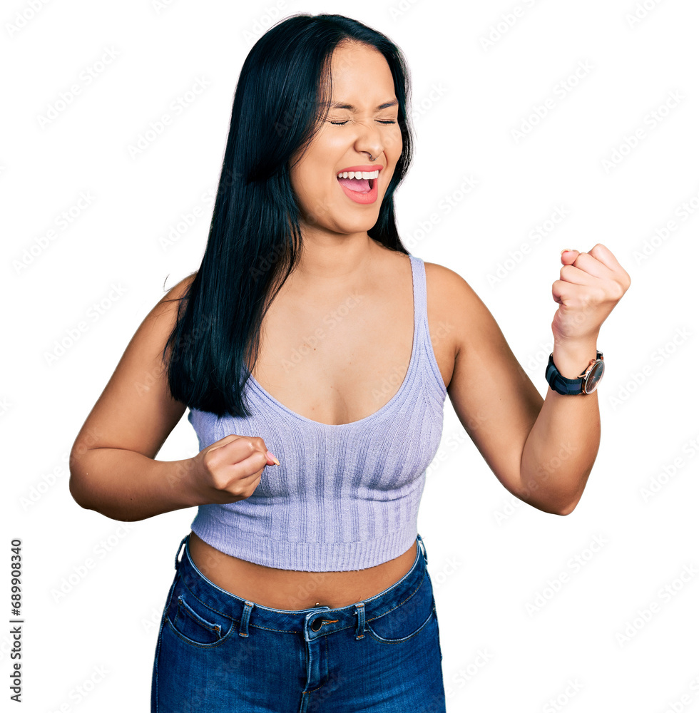 Beautiful hispanic woman wearing casual style with sleeveless shirt celebrating surprised and amazed for success with arms raised and eyes closed Beautiful hispanic woman wearing casual style with sleeveless shirt celebrating surprised and amazed for success with arms raised and eyes closed