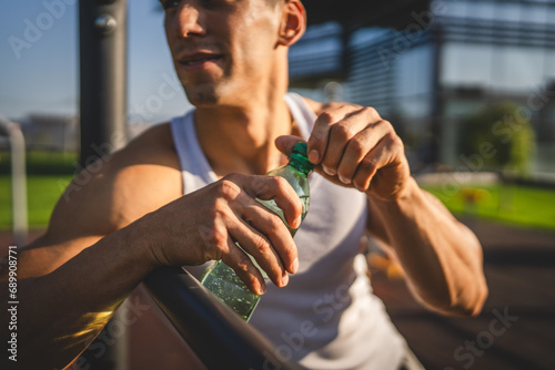 man young male athlete hold bottle of water drink training outdoor