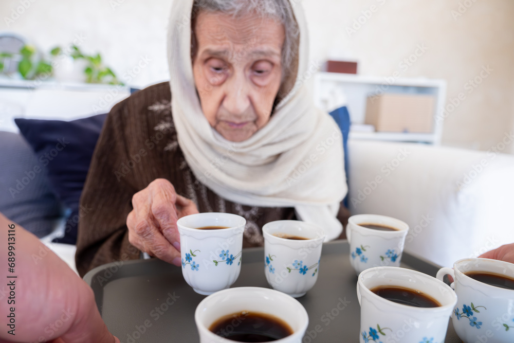 Cheerful arabian old woman is offered a cup of coffee as a hospitality Cheerful arabian old woman is offered a cup of coffee as a hospitality