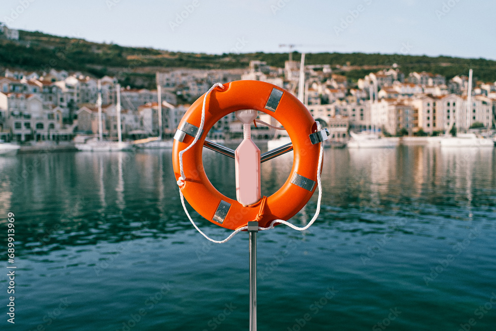 Lifebuoy with ropes hanging from a metal stand on the pier