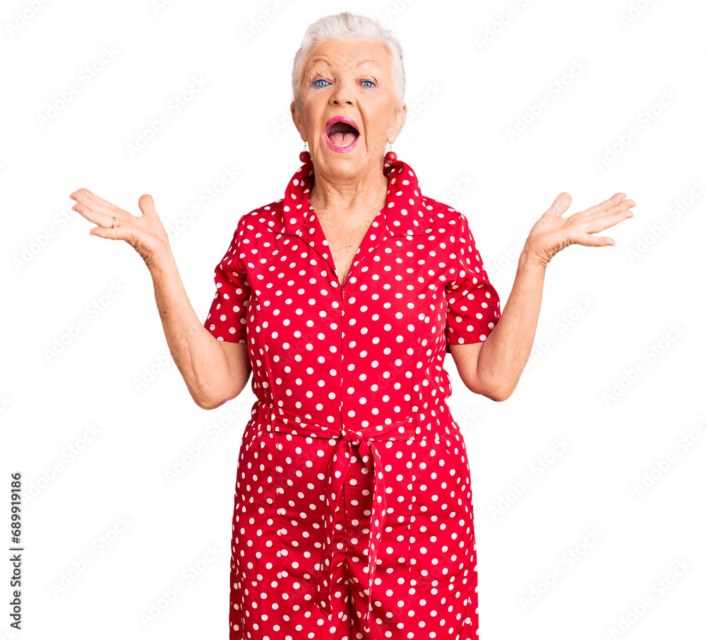 Senior beautiful woman with blue eyes and grey hair wearing a red summer dress celebrating crazy and amazed for success with arms raised and open eyes screaming excited. winner concept Senior beautiful woman with blue eyes and grey hair wearing a red summer dress celebrating crazy and amazed for success with arms raised and open eyes screaming excited. winner concept