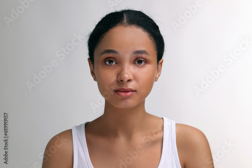 Portrait of beautiful woman looking at camera on light background