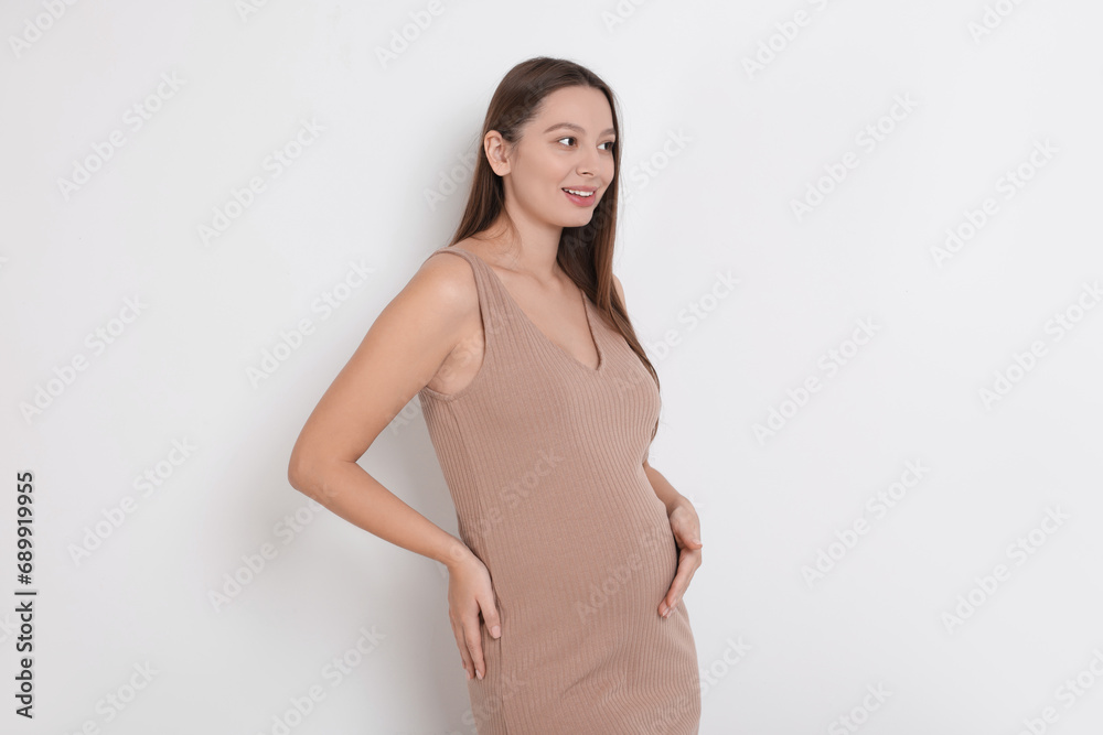 Beautiful pregnant woman in beige dress on white background Beautiful pregnant woman in beige dress on white background