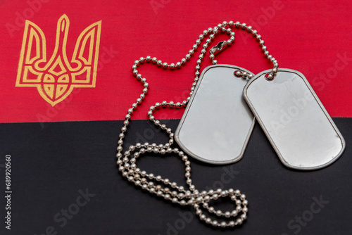 Army medallion of a soldier on the background of Ukrainian red and black flag. Concept: fight for freedom, war in ukraine, mobilization and conscription.